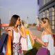 doua femei la un outlet cu pungi de cumparaturi haine
